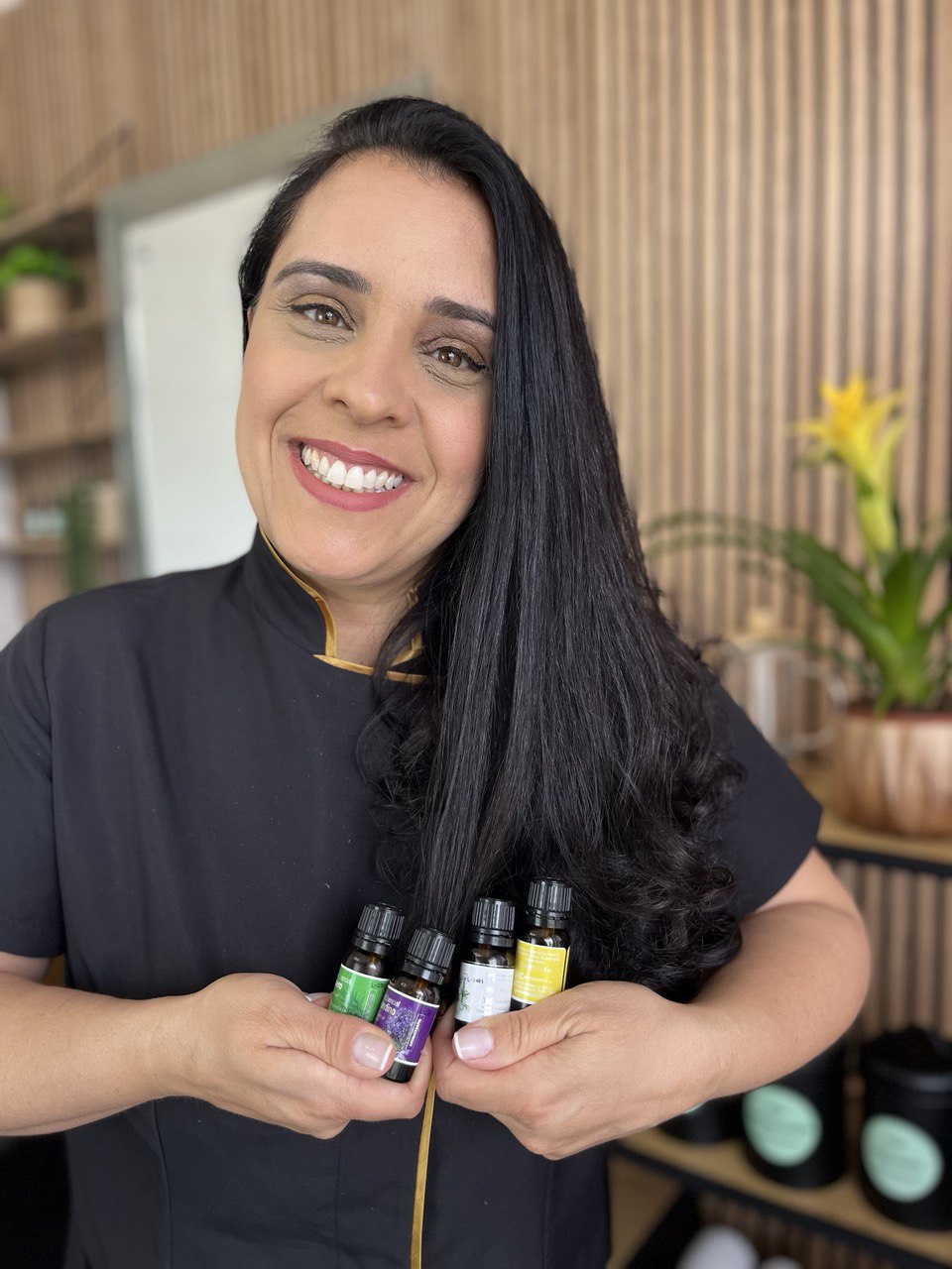 Kelly Marques, especialista em terapia capilar, com produtos de tratamento